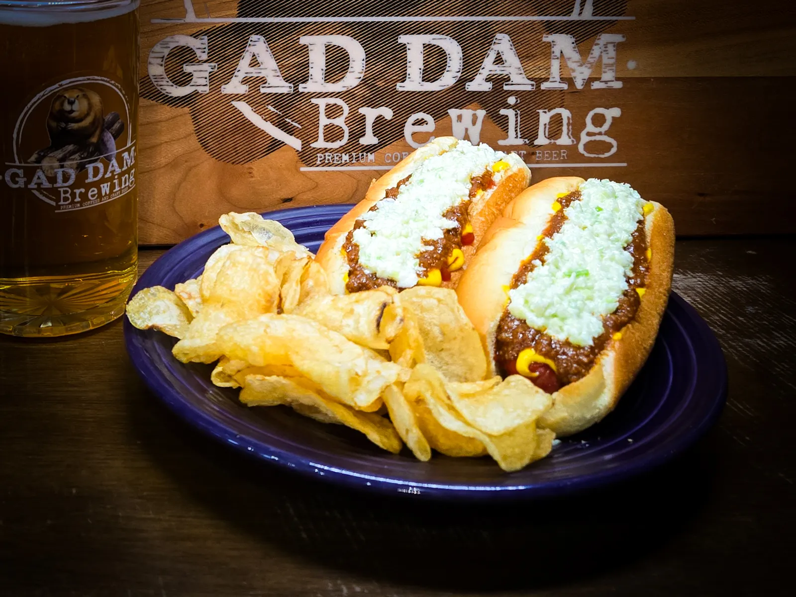 Two beef hotdogs topped with mustard, chili, and slaw.